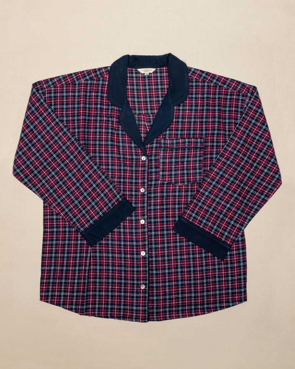 Burgundy and blue plaid shirt with navy trim on a beige background