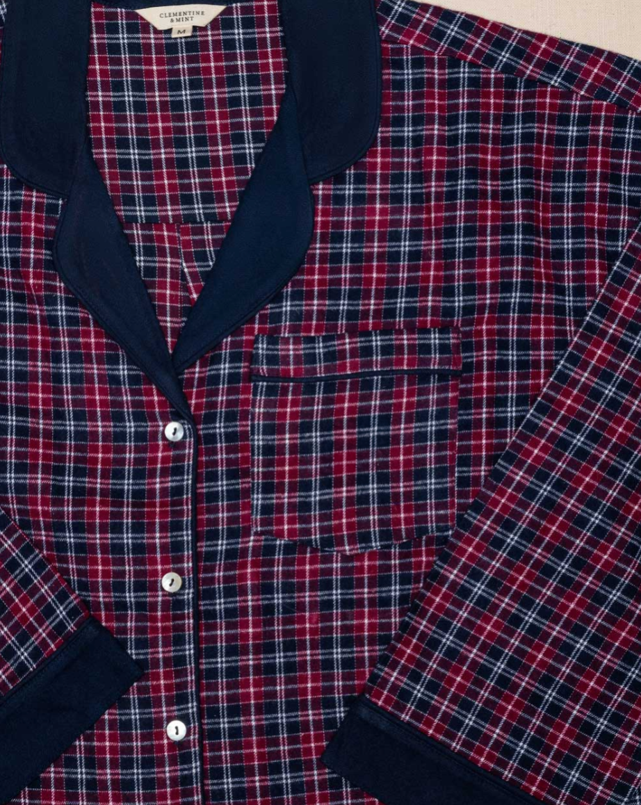 Red and navy plaid shirt with navy blue accents on a neutral background