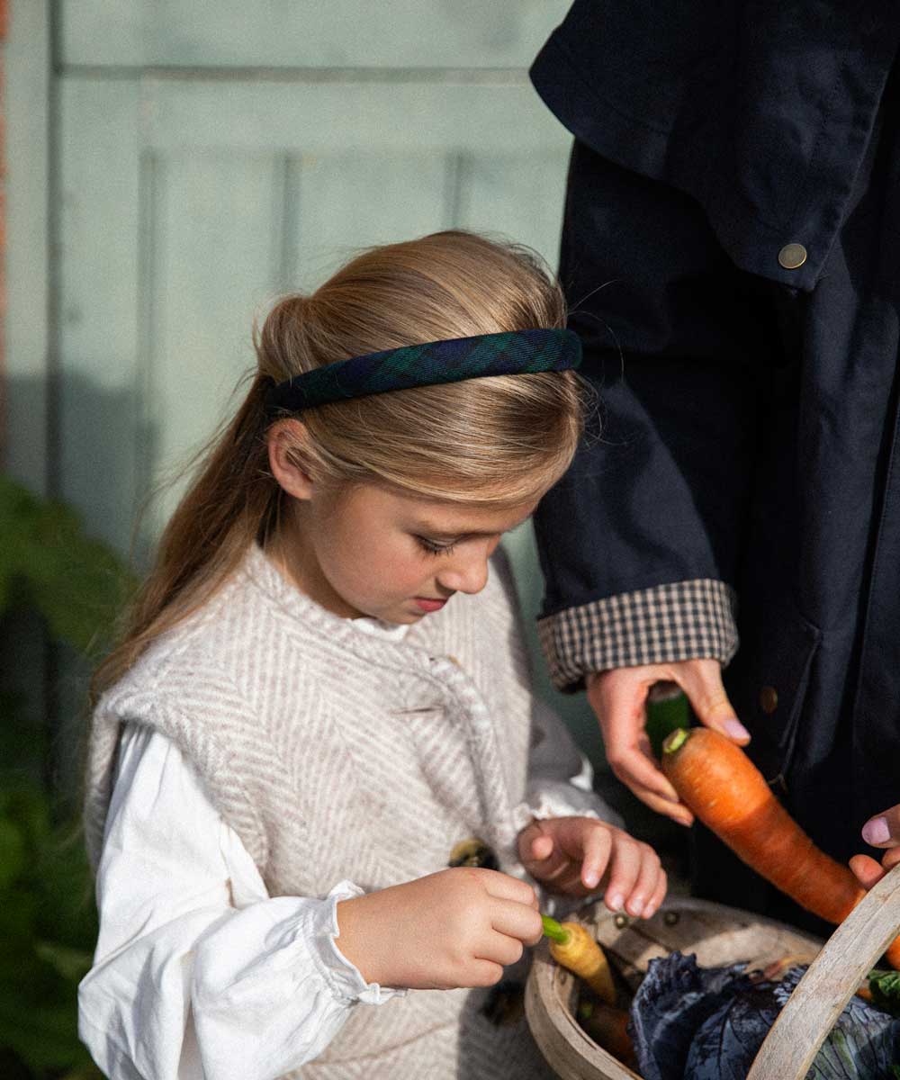 young girl wearing black watch tartan headband