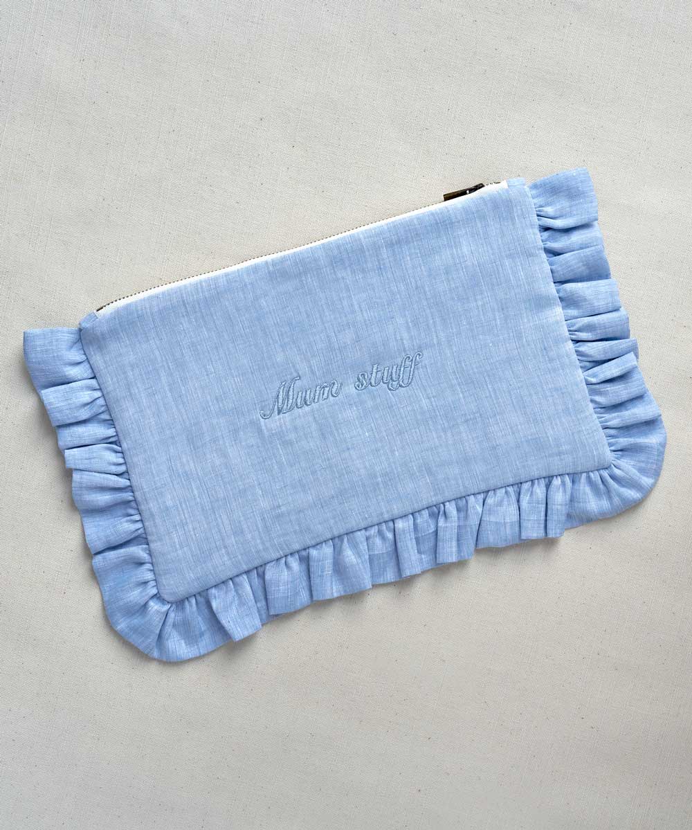 Blue clutch with ruffled edge and 'Mum Stuff' embroidery on a light gey background