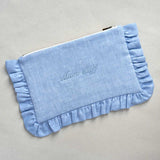 Blue clutch with ruffled edge and 'Mum Stuff' embroidery on a light gey background