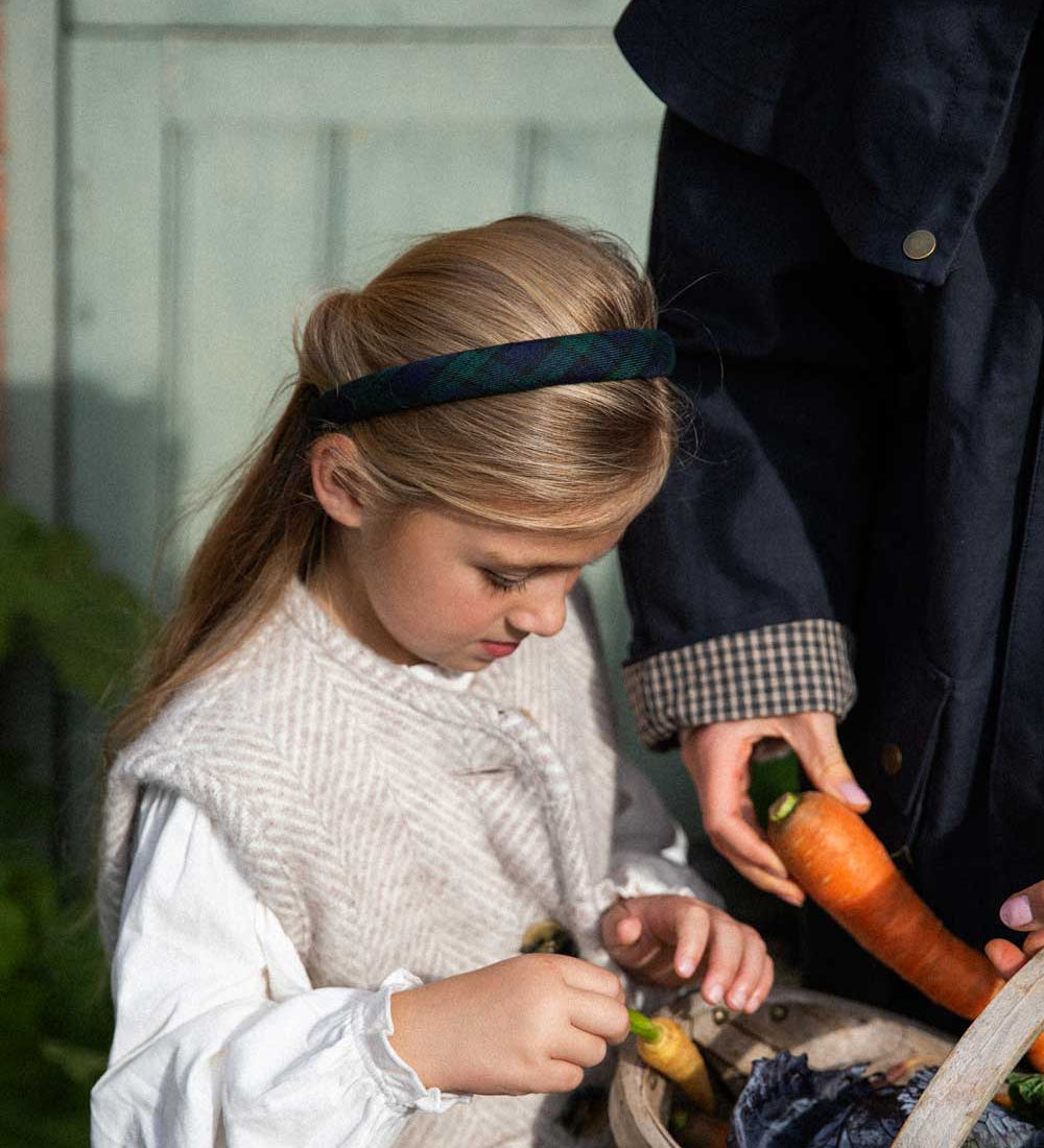 young girl wearing black watch tartan headband 