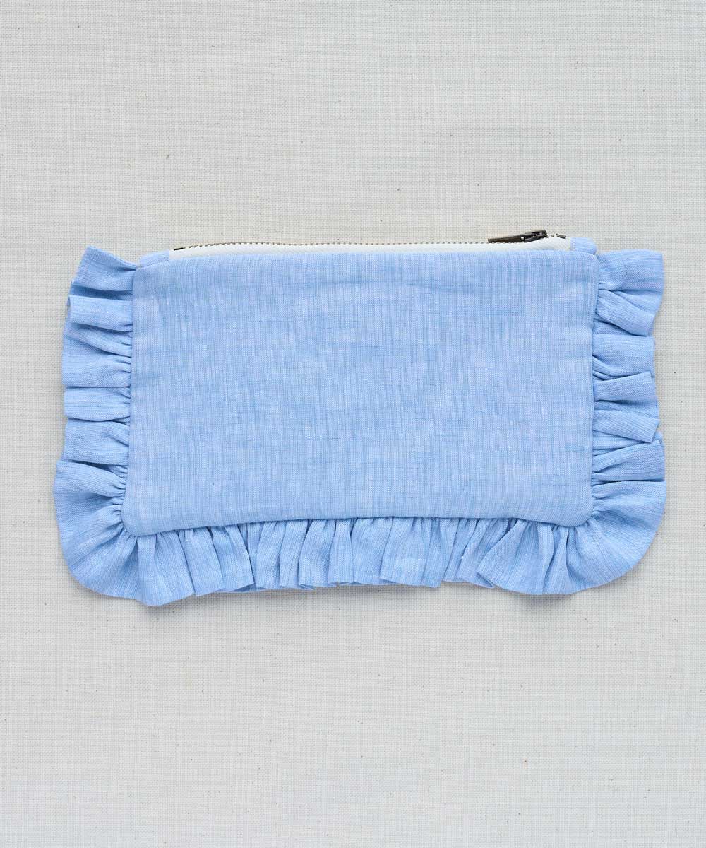 Blue mini pouch with ruffled edges on a grey background