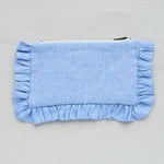 Blue mini pouch with ruffled edges on a grey background