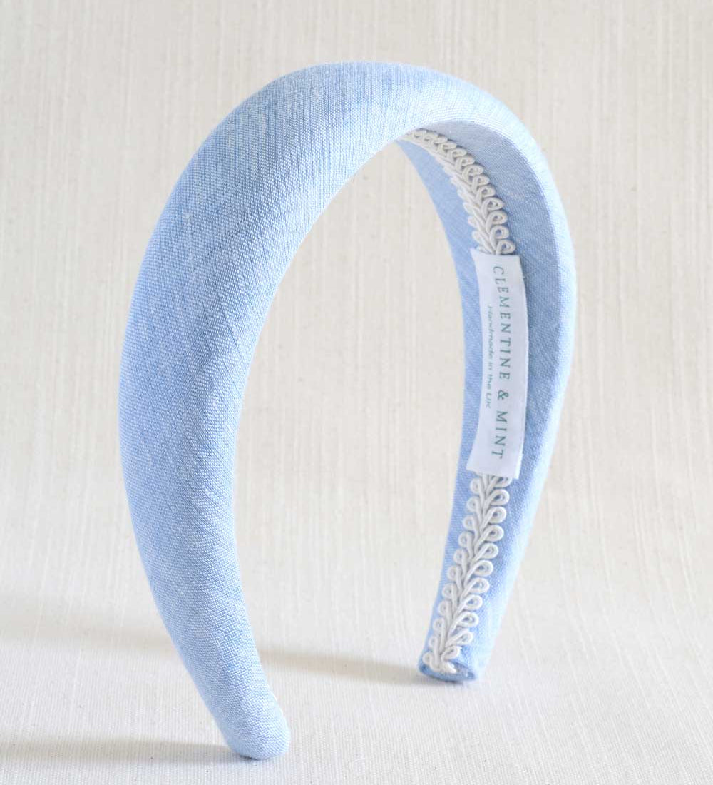 Light blue headband with decorative band on a white background