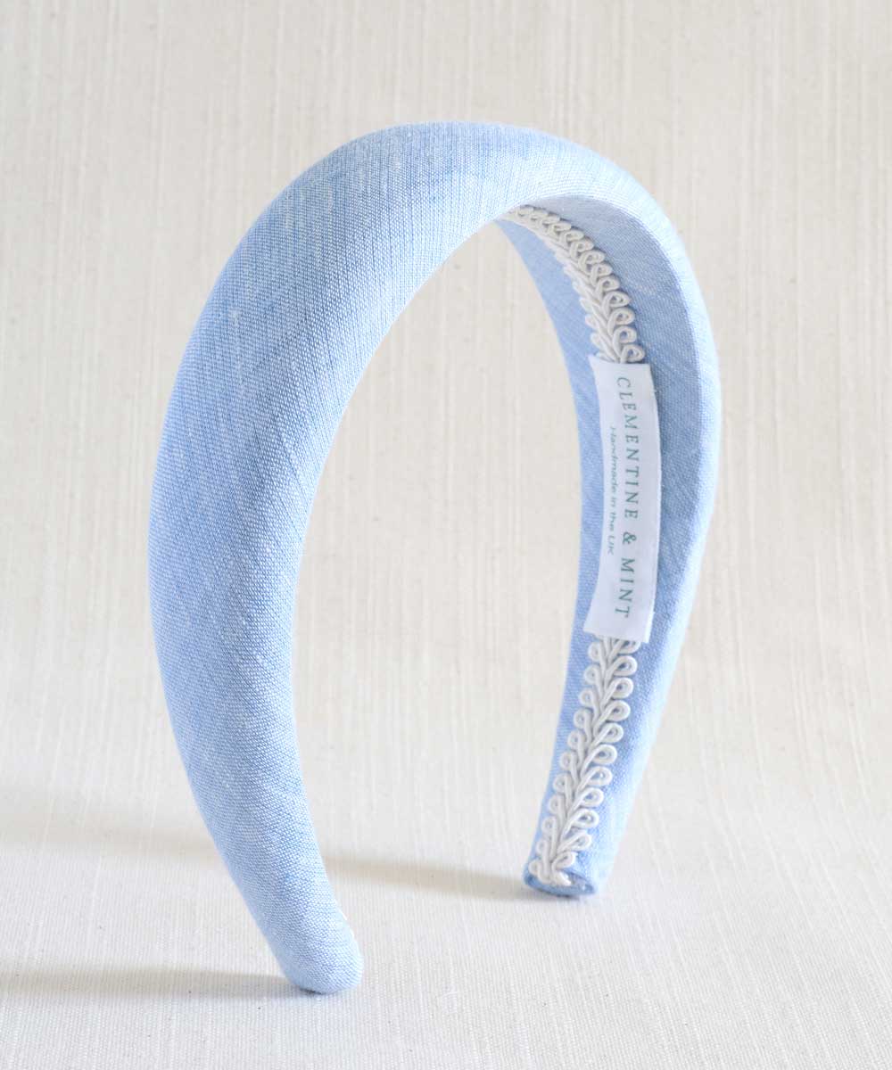 Light blue headband with decorative band on a white background