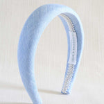 Light blue headband with decorative band on a white background