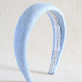 Light blue headband with decorative band on a white background