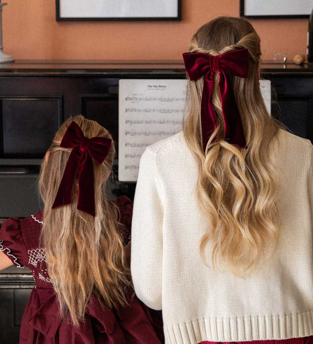 mother and daughter wearing matching burgundy velvet hairbows 