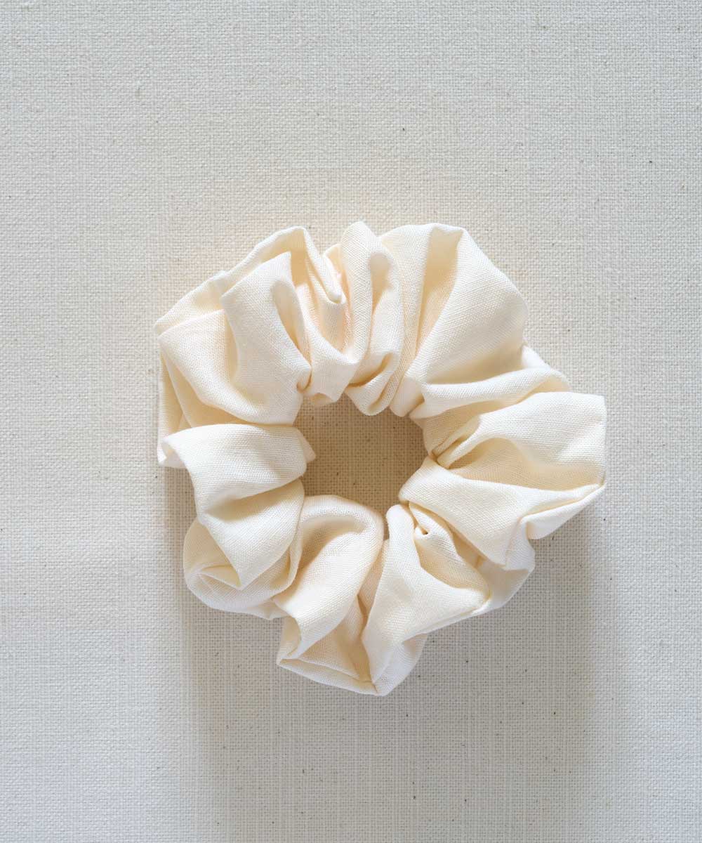 Cream-colored scrunchie on a light gray background