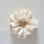 Cream-colored scrunchie on a light gray background
