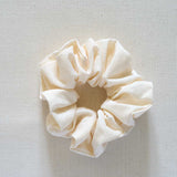 Cream-colored scrunchie on a light gray background