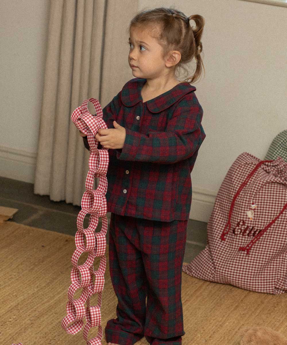 child wearing a burgundy tartan pyjama 