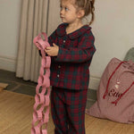 child wearing a burgundy tartan pyjama 