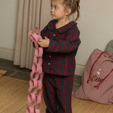 child wearing a burgundy tartan pyjama 