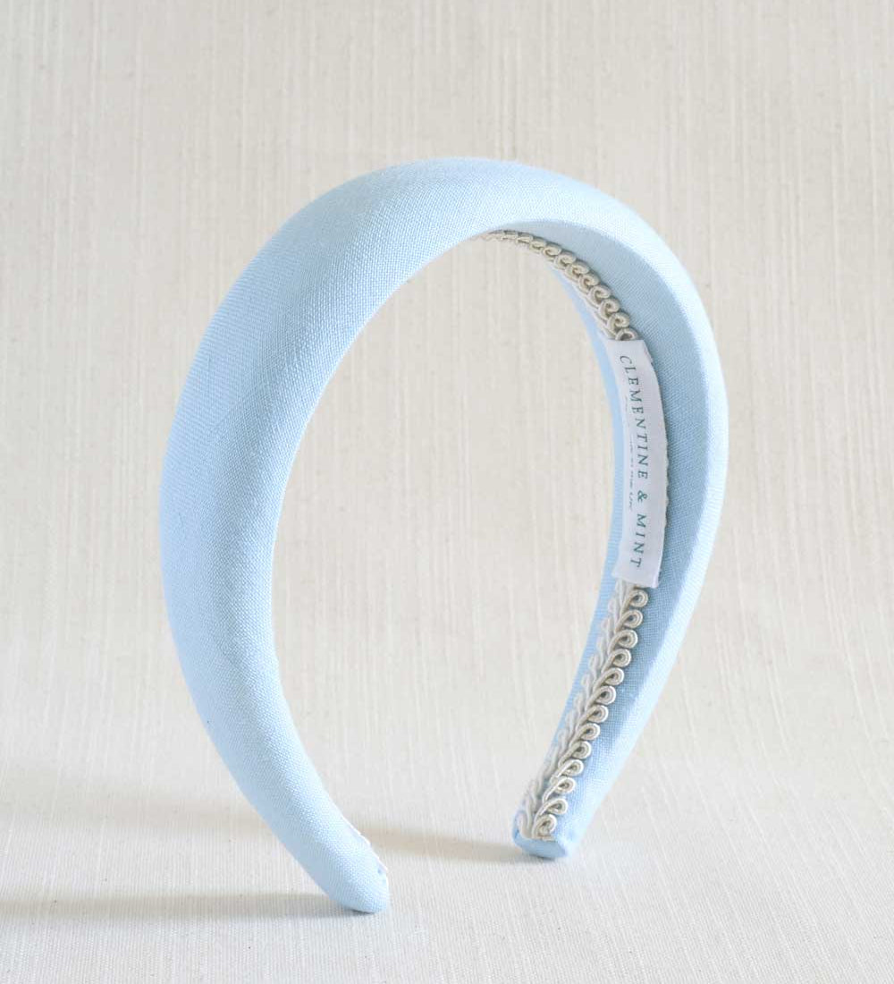 Light blue headband with a braid detail on a beige background