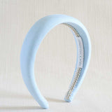 Light blue headband with a braid detail on a beige background