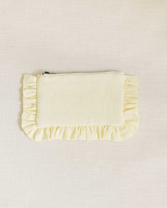 A small light yellow ruffled pouch with a brass zip closure, made of Irish Linen fabric.