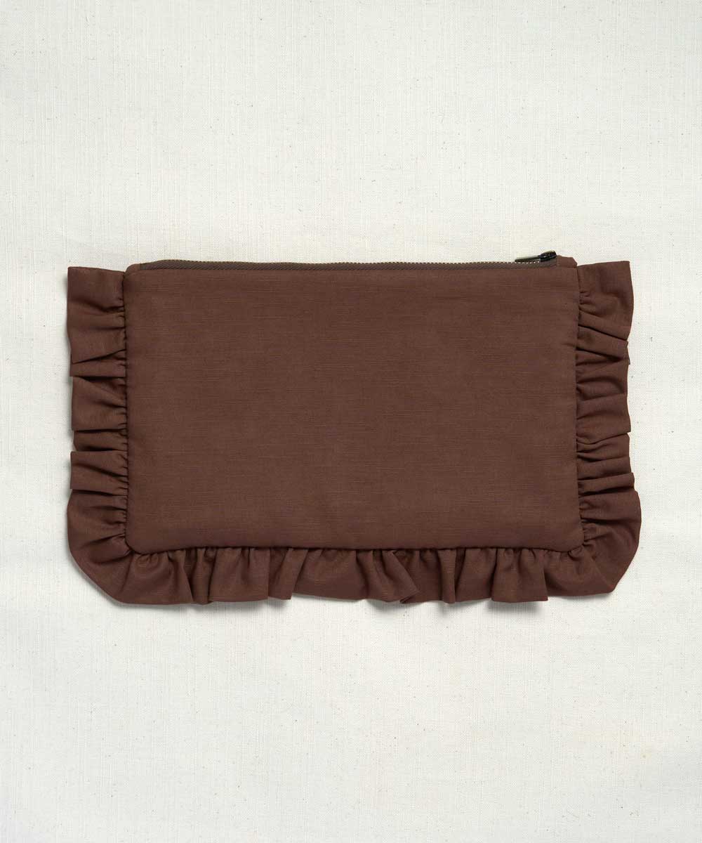 A brown fabric clutch or pouch with ruffled trim on all sides, photographed flat against a light off-white textured background.