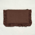 A brown fabric clutch or pouch with ruffled trim on all sides, photographed flat against a light off-white textured background.