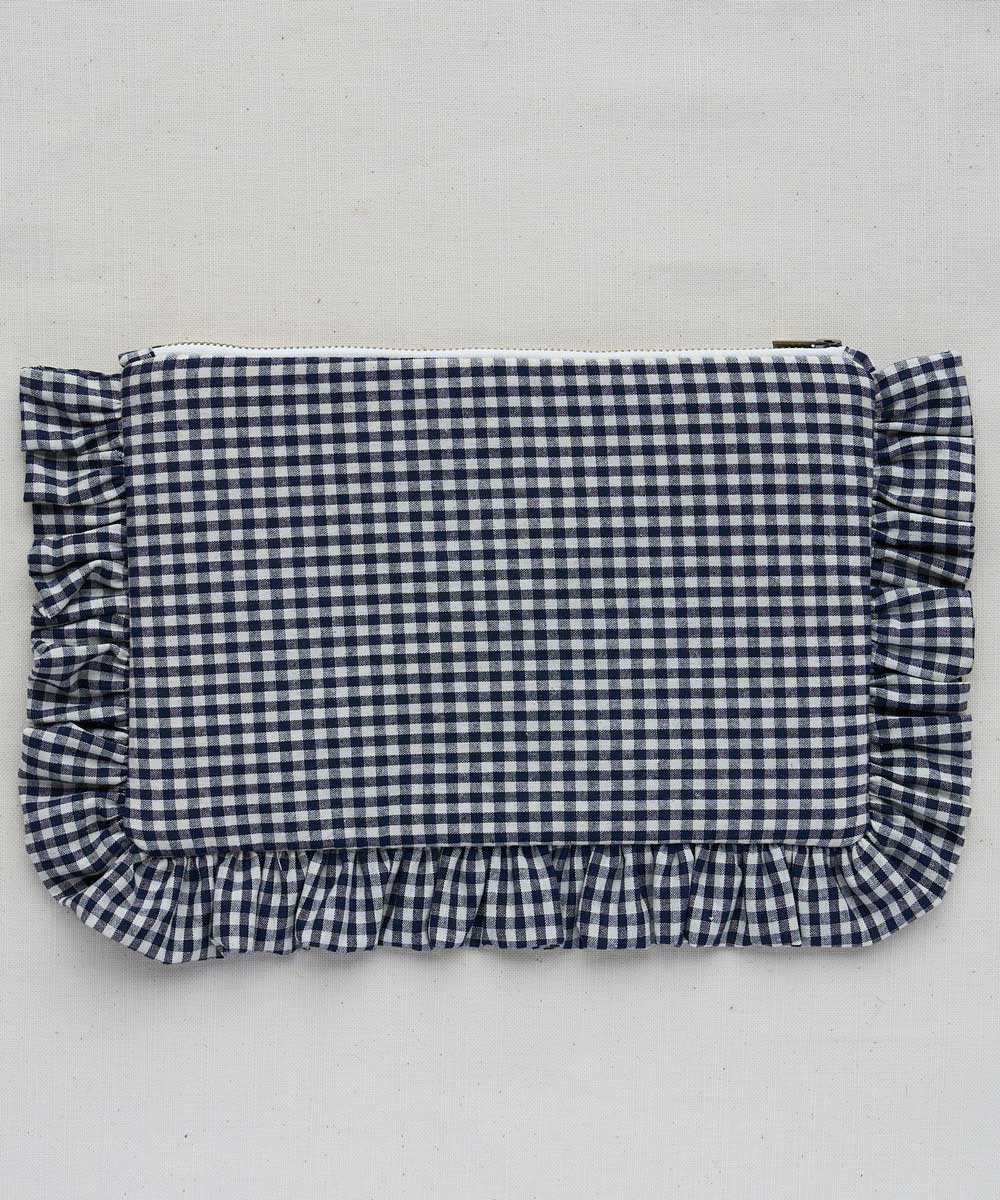 Blue and white checkered pouch with ruffled edges on a light gray background