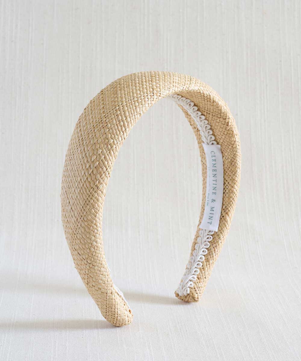 Beige woven headband with a white label on a light background