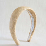 Beige woven headband with a white label on a light background