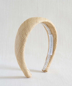 Beige woven headband with a white label on a light background