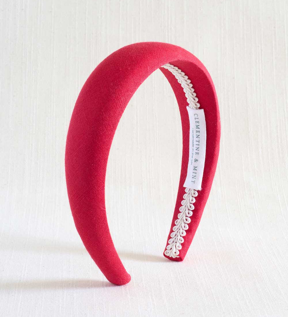 Red headband with lace detail on a white background