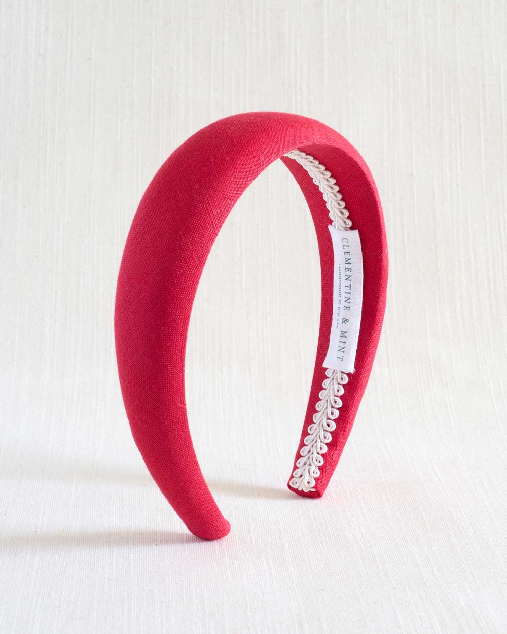 Red headband with lace detail on a white background