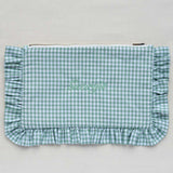 Green gingham clutch bag with ruffled edge on a light gray background