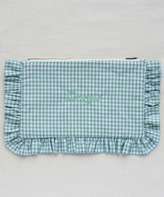 Green gingham clutch bag with ruffled edge on a light gray background